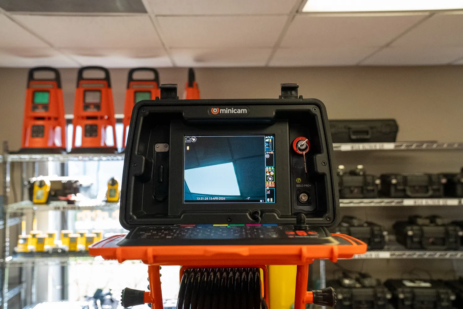 Minicam push camera control unit with its monitor on, set up in the Tiger Safety Rentals equipment room